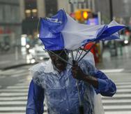 Un hombre intenta cubrirse con su paraguas deformado bajo la lluvia provocada por la tormenta tropical Fay el viernes 10 de julio de 2020, en Nueva York.