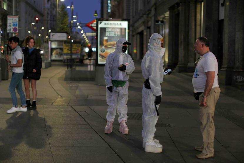 Personas utilizan ropa de protección ante el alto riesgo de contagio en España. (AP)