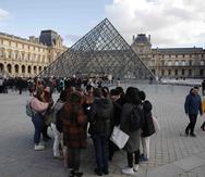Turistas esperan y empleados en huelga se manifiestan en la entrada al Museo del Louvre. (AP/Francois Mori)