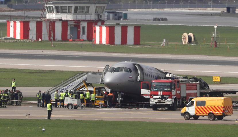 Miembros de los servicios de emergencia permanecen junto al fuselaje del avión incendiado en el aeropuerto moscovita de Sheremétievo, Rusia. (EFE)