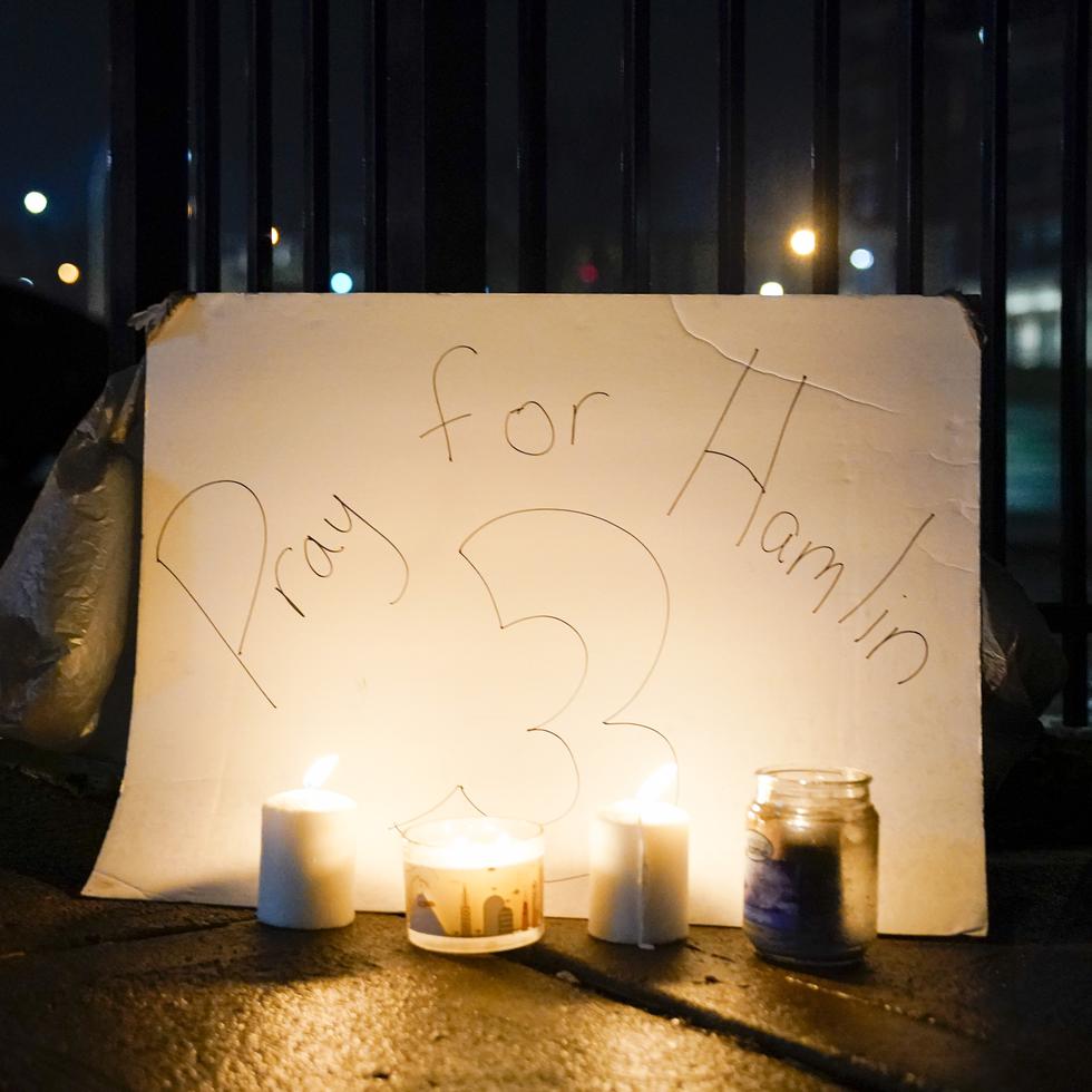 Aficionados colocan un cartel y velas afuera del Centro Médico de la Universidad de Cincinnati, lugar donde Damar Hamlin está recluido.