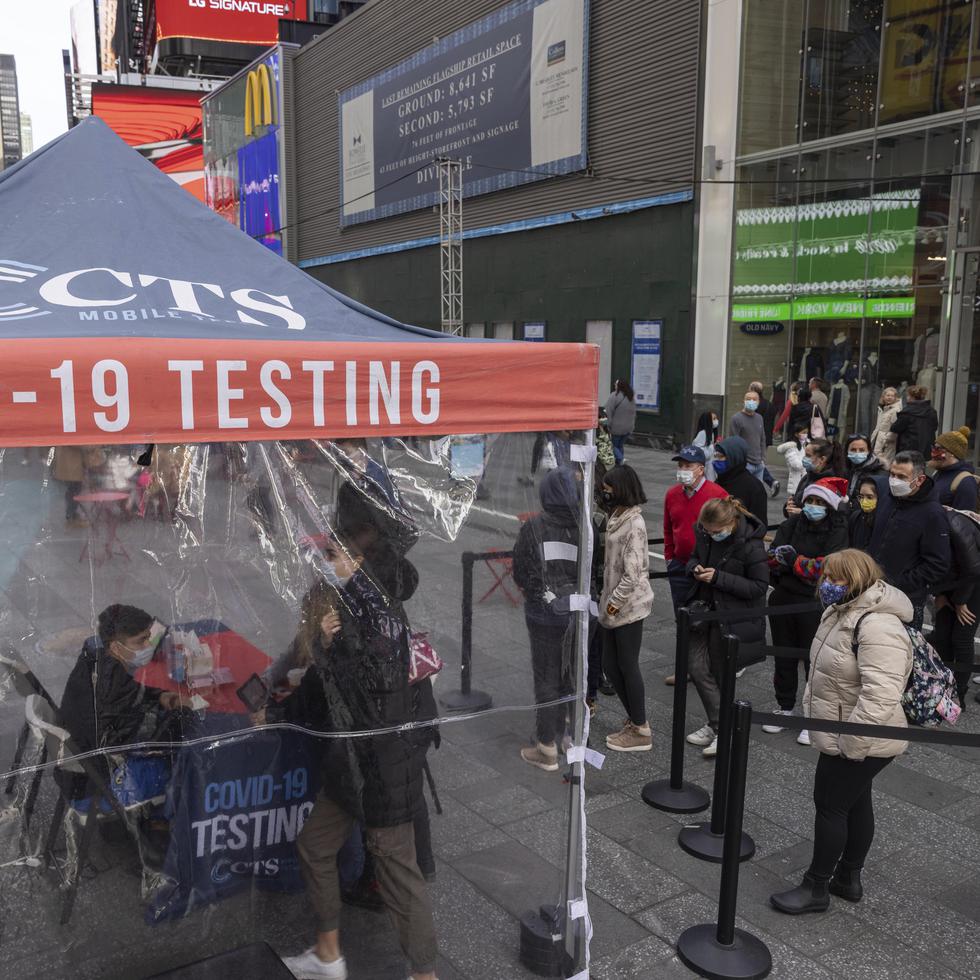 Varias personas hacen fila para que les efectúen una prueba diagnóstica de COVID-19 en un centro móvil en Times Square.