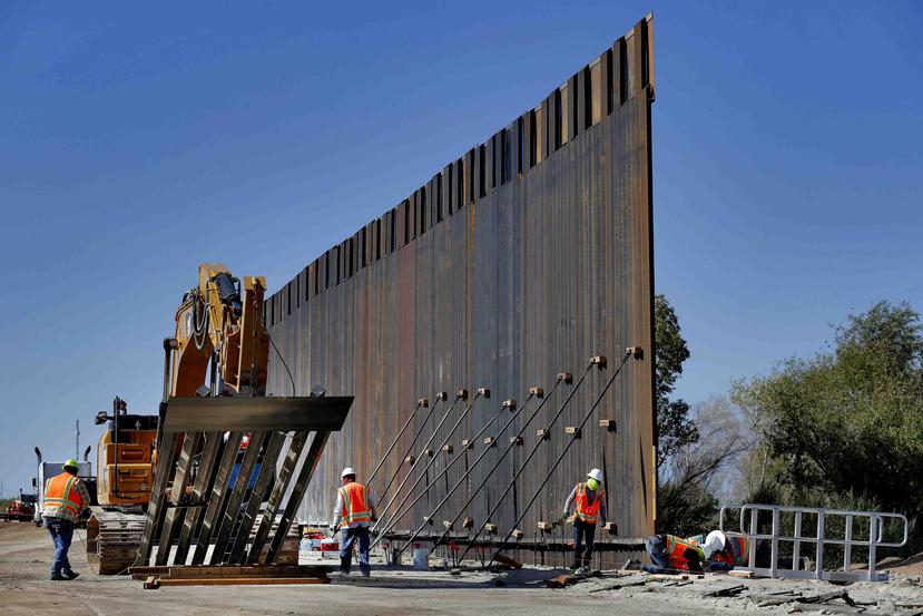Con la ayuda a una grúa gigantesca, trabajadores instalan secciones de un muro pensado para frenar el cruce ilegal de la frontera EEUU con México en Yuma, Arizona. (AP)