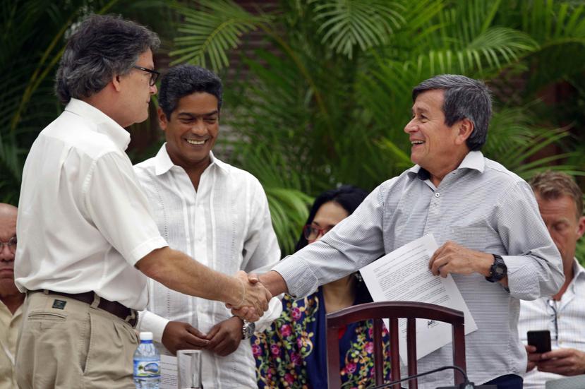 El jefe negociador del gobierno colombiano, Gustavo Bell (izq.), estrecha la mano del comandante del ELN Israel Ramírez Pineda (der.), alias Pablo Beltrán. (EFE / Ernesto Mastrascusa)