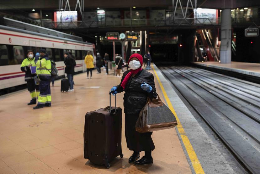Una pasajera con máscara y guantes espera un tren en la estación de Atocha, Madrid, hoy lunes. (AP)