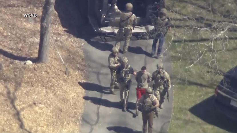 ARCHIVO - La imagen de un video provisto por WCVB-TV, muestra a Jack Teixeira, de camiseta y pantalones cortos, al ser arrestado por agentes armados el 13 de abril de 2023. (WCVB-TV via AP)