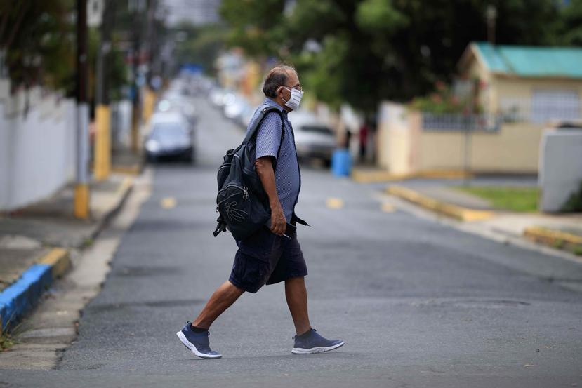 Un hombre camina protegido con una mascarilla por Barrio Obrero, en San Juan.