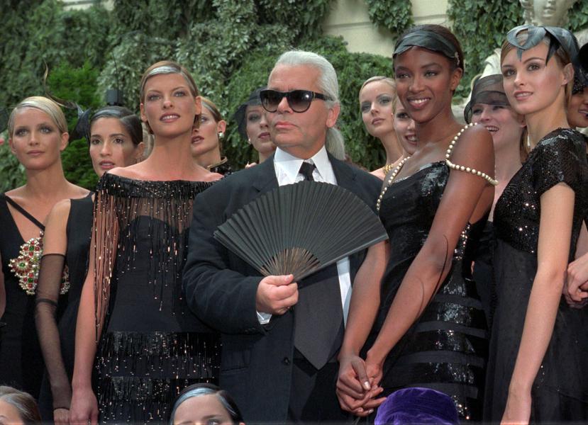 El modisto posa junto a las modelos Linda Evangelista y Naomi Campbell luego de un desfile de Chanel en París en julio de 1996. (AP)