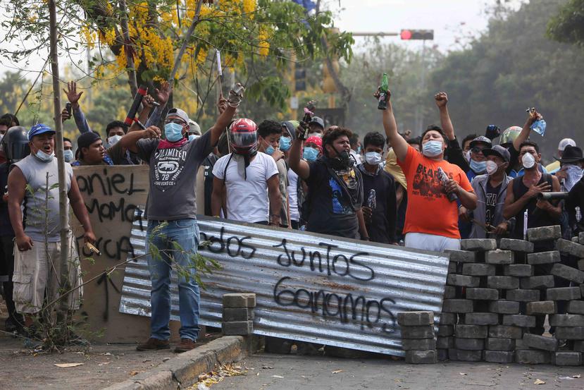 Un grupo de manifestantes lanza consignas tras bloquear una calle en un confrontamiento con las fuerzas de seguridad cerca de la Universidad Politécnica de Nicaragua (UPOLI) en Managua, Nicaragua. (AP)