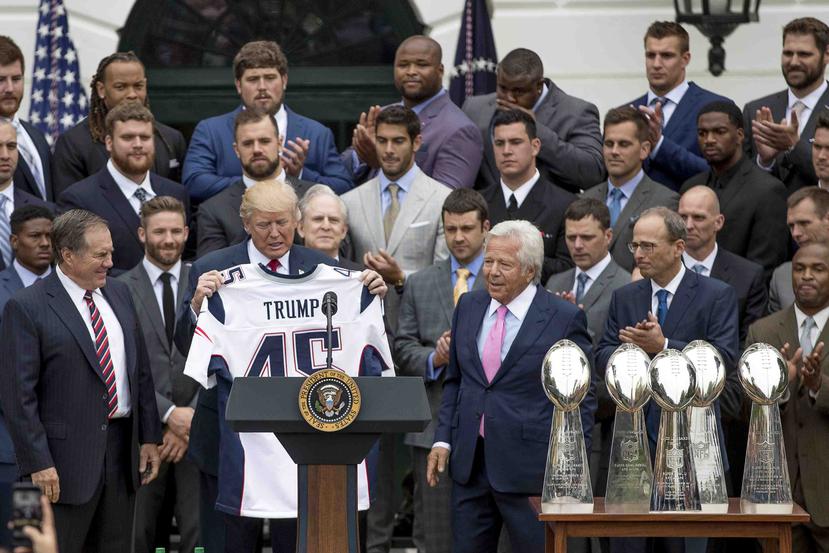 Trump recibe la camiseta de los Patriots de la mano dl dirigente Bill Belichick y el dueño de la franquicia, Robert Kraft. (AP)