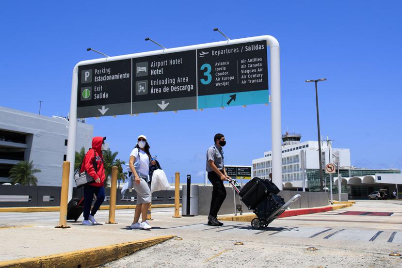 Varias personas con mascarillas en el aeropuerto internacional Luis Muñoz Marín.