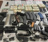 La foto muestra el dinero en efectivo y varias de las piezas de armas de fuego ocupadas durante el diligenciamiento de la orden de registro y allanamiento en el barrio Cucharillas.