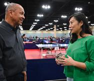 El presidente de la Federación Puertorriqueña de Tenis de Mesa, Iván Santos (izquierda), conversa con su homóloga de Estados Unidos, Virginia Sung.