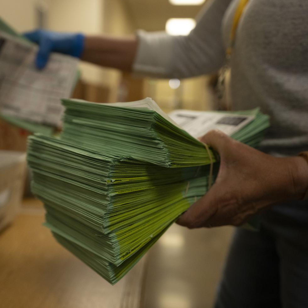 Un funcionario electoral envía papeletas por correo en el Centro Electoral y de Tabulación del condado de Maricopa, en Phoenix, Arizona.
