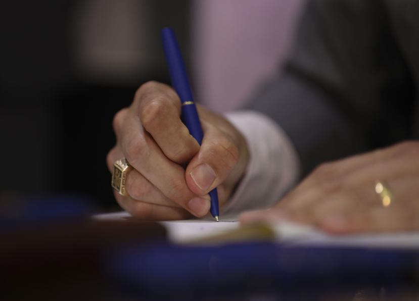 El exgobernador Ricardo Rosselló firma un documento. (GFR Media)