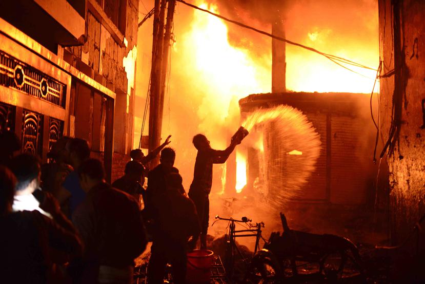 Bomberos y civiles combaten un incendio en Daca, Bangladesh. (AP)