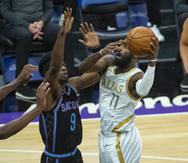 El jugador de los Mavericks de Dallas Tim Hardaway Jr. (con el 11) lanza a canasta mientras el jugador de los Kings de Sacramento Terence Davis (9) defiende, en el primer cuarto de su juego de NBA en Sacramento, California.