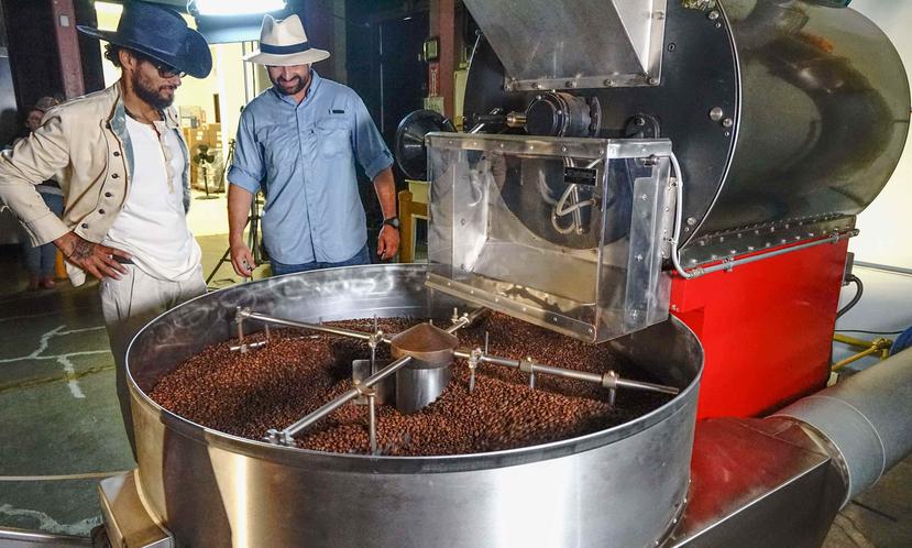 El cantautor Draco Rosa y el agroempresario Lester Marín observan parte del proceso de confección del café que se venderá en Walmart. (Suministrada)