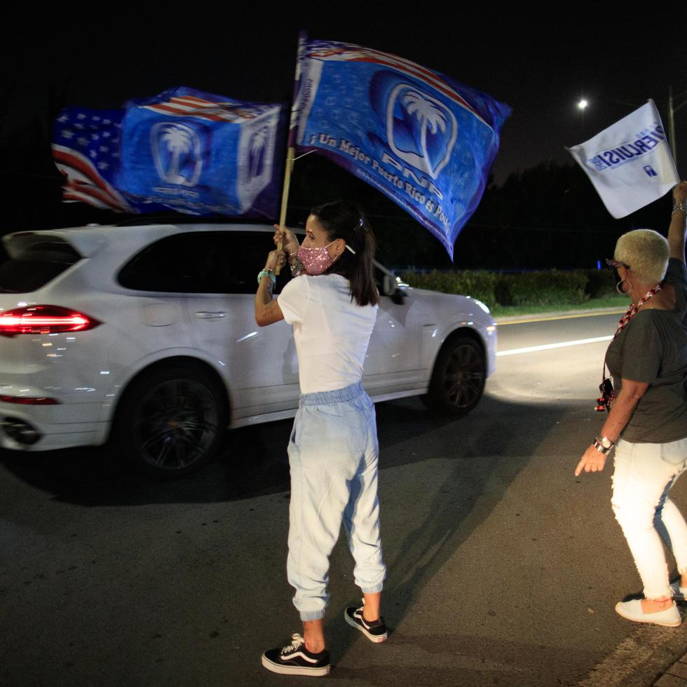 Varios partidarios ondean sus banderas del PNP frente a Vivo Beach Club en Carolina.