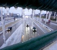 Concentraciones de hielo en un pasamanos sobre la carretera federal 75, el miércoles 1 de febrero de 2023, en Dallas. (AP Foto/Tony Gutierrez)