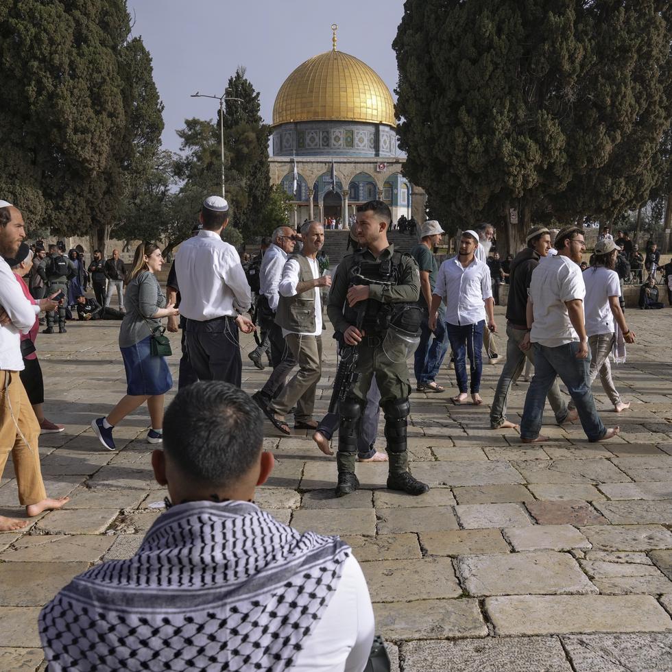 Policías israelíes escoltan a visitantes judíos en que celebran la Pascua judía en el complejo de la Mezquita de Al Aqsa, conocido por los musulmanes como Noble Santuario y por los judíos como Monte del Templo, en el casco antiguo de Jerusalén, durante el mes sagrado del Ramadán, el domingo 9 de abril de 2023. (AP Foto/Mahmoud Illean)