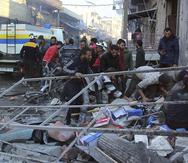 Trabajadores de la organización y otras personas buscando por víctimas debajo de los escombros luego de unos ataques aéreos en Balyoun, Siria. (Defensa Civil Siria vía AP)
