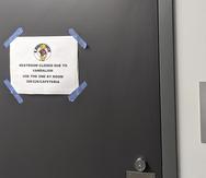 En esta fotografía del viernes 17 de septiembre de 2021, cortesía de Cuyler Dunn, se muestra un letrero en un baño para informar que fue cerrado debido a actos de vandalismo en una escuela secundaria de Lawrence, Kansas.