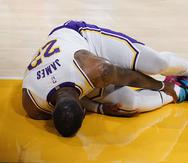 Lebron James se aguanta con dolor el tobillo derecho luego de lesionarse en el partido de los Lakers contra los Hawks.