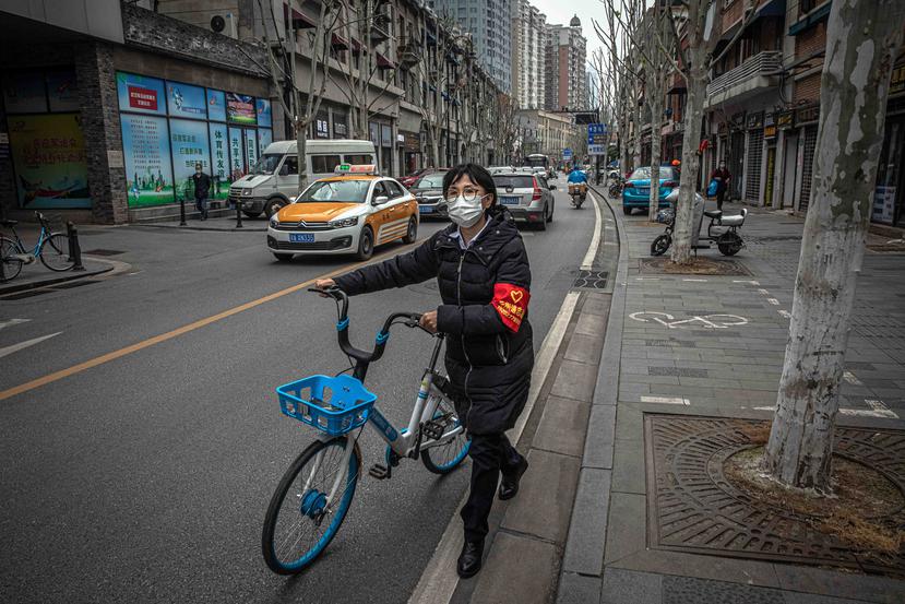 Una mujer utiliza una mascarilla protectora mientras camina por las calles de Wuhan. (EFE)