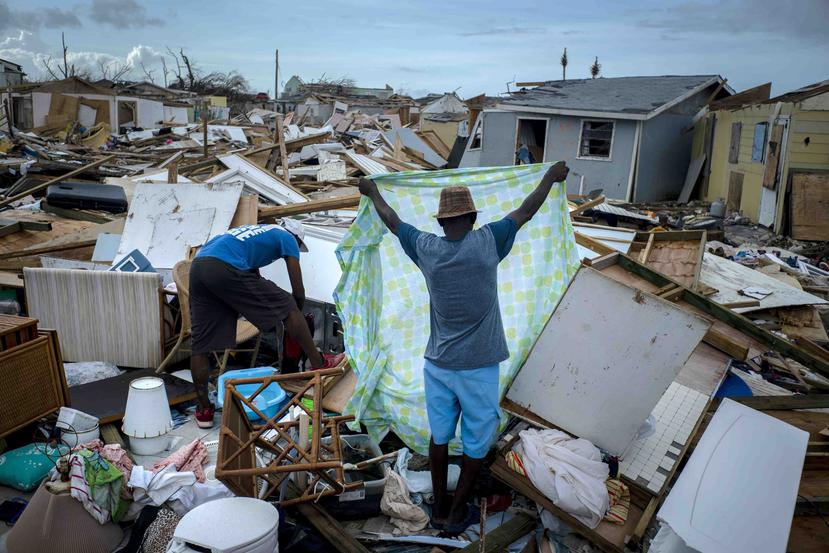 Inmigrantes haitianos recuperan sus pertenencias de entre los escombros de sus casas destruidas tras el paso del huracán Dorian en Ábaco, Bahamas. (AP)