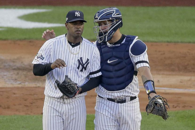 El catcher dominicano Gary Sánchez de los Yankees de Nueva York platica en la lomita con su compatriota Luis Severino (40), el pitcher abridor, en el tercer partido de la Serie de Campeonato de la Liga Americana. (AP)