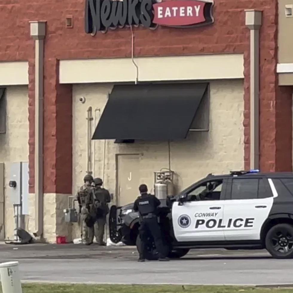 Vehículos policiales en el centro comercial Lewis Crossing Shopping Center, en Conway, Arkansas, donde un hombre armado embisitió con su auto un local y se atrincheró en el lugar.