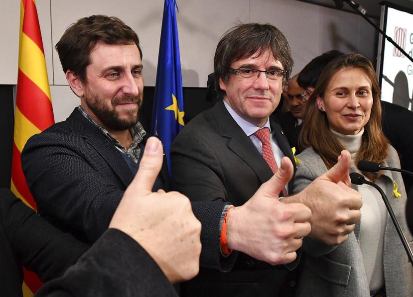 El líder catalán destituido Carles Puigdemont, centro, y el ex ministro de Salud catalán Antoni Comin, izquierda, levantan los pulgares en una conferencia de prensa en Bruselas (AP).