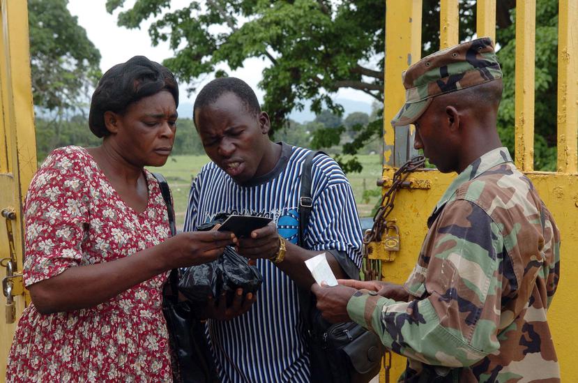 Un soldado del ejército dominicano revisa la documentación de dos ciudadanos haitianos en la frontera entre ambos países. (EFE)