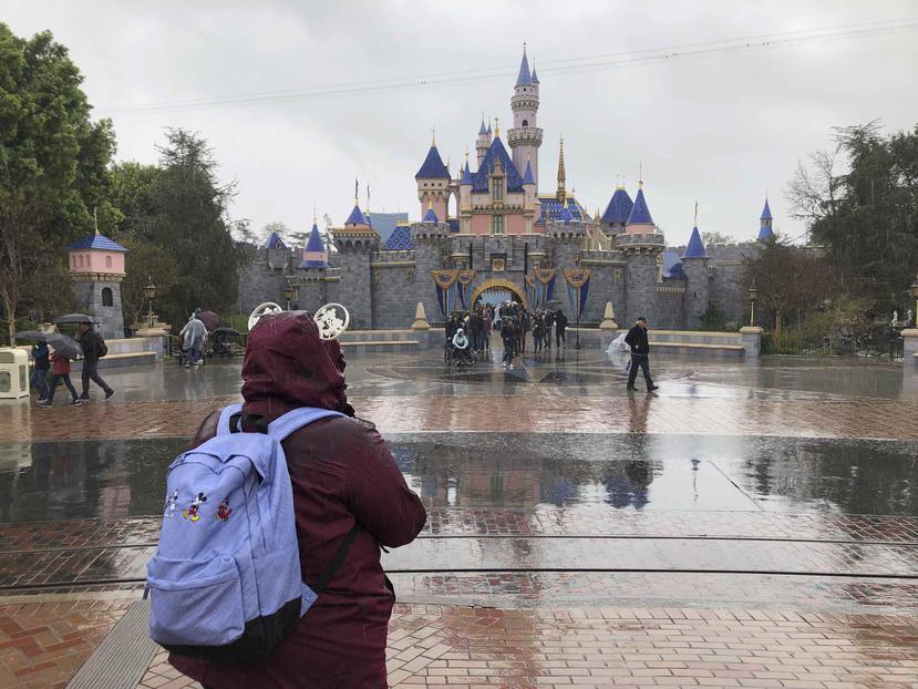 Fue un inusual día lluvioso en el sur de California, y los visitantes con impermeables de plástico buscaban pasearse en la mayor cantidad de atracciones posible. (AP)