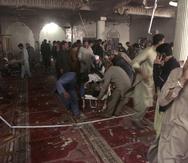 Trabajadores de rescate y voluntarios retiran un cuerpo del lugar de la explosión de una bomba en una mezquita en Peshawar, Pakistán, el viernes 4 de marzo de 2022.