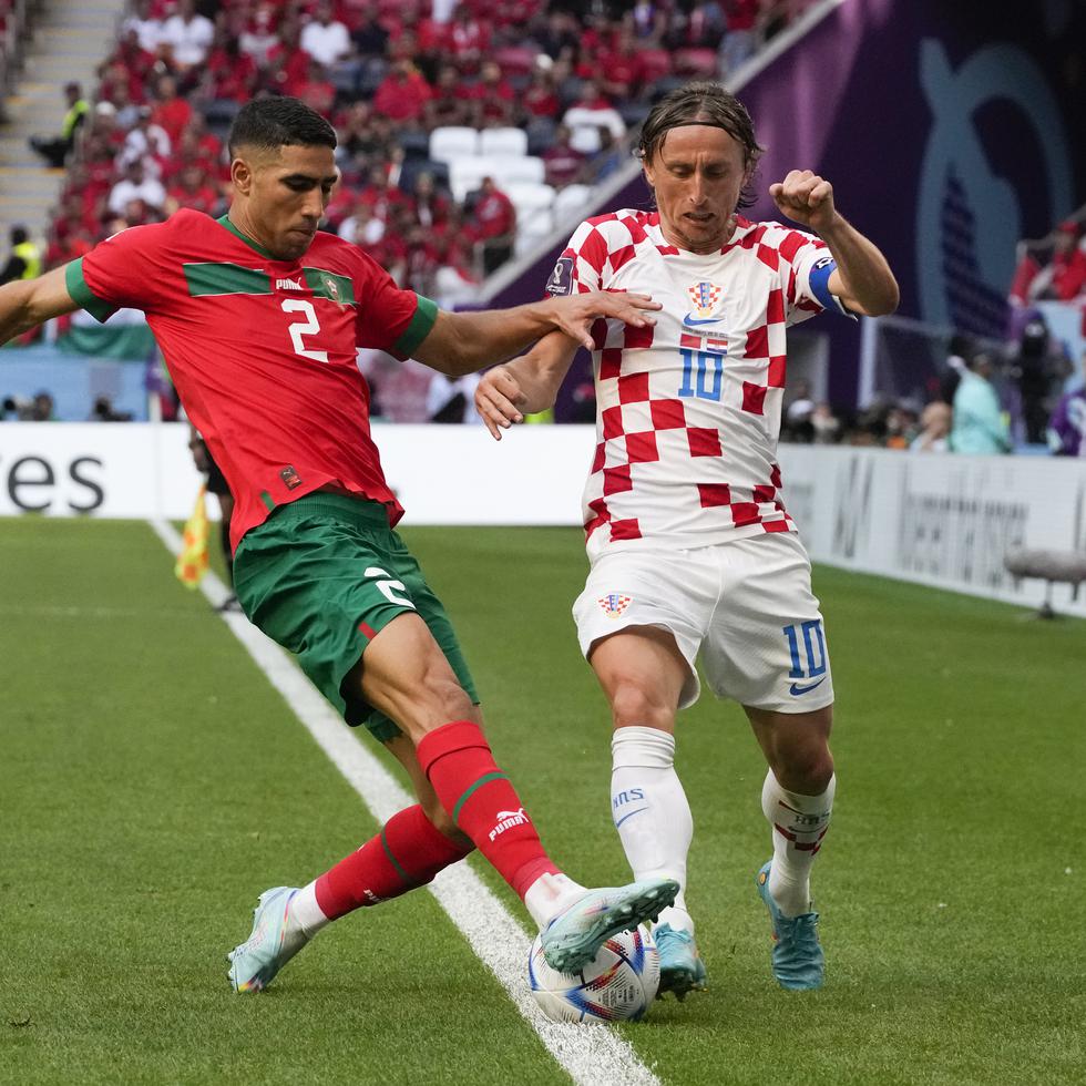 El croata Luka Modric (derecha) y el marroquí Achraf Hakimi, pugnan por el balón en un juego del Grupo F del Mundial entre ambos países, en el estadio Al Bayt, en Jor, Catar.
