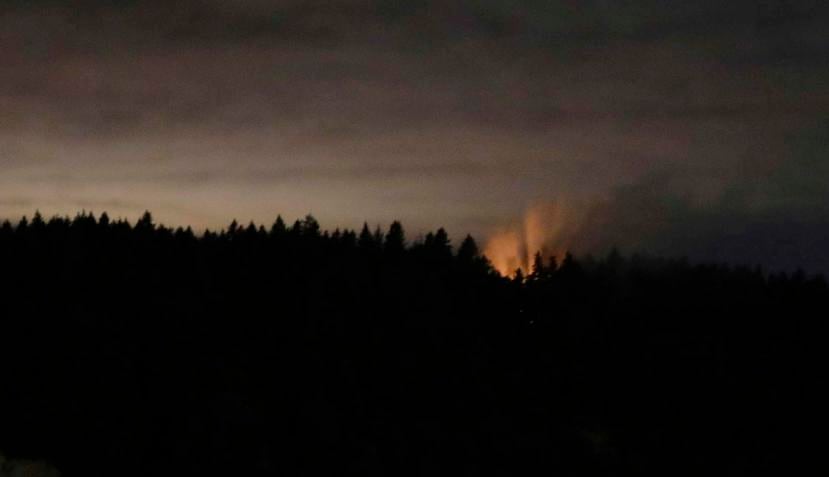Esta foto del sábado, 11 de agosto del 2018 se ven humo y un resplandor naranja sobre la isla Ketron, en el estado de Washington. (AP)