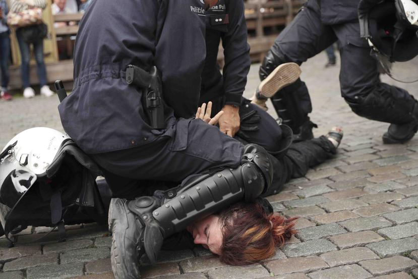La policía detiene a una mujer durante una protesta del movimiento chalecos amarillos con otros grupos en Bruselas, Bélgica, el domingo 26 de mayo de 2019. (AP/Francisco Seco)