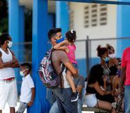 Varias personas esperan en una parada de autobus, en La Habana (Cuba).