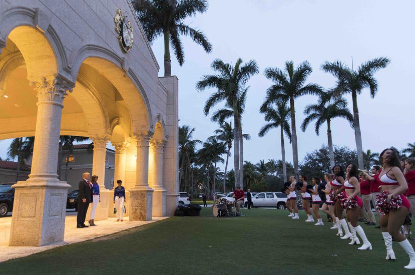 El presidente Donald Trump y la primera dama Melania Trump asisten a una presentación de la Banda Musical y las animadoras de la Universidad Atlantic de Florida en el Club Internacional de Golf Trump en West Palm Beach, Florida. (AP)
