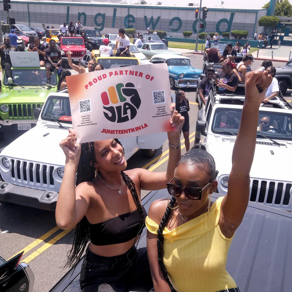Jasmine Kingi, left, 26, and Robin Renee Green, 26, both from Los Angeles, celebrate as they take part in a car parade to mark Juneteenth, Saturday, June 19, 2021, in Inglewood, Calif. (AP Photo/Ringo H.W. Chiu)