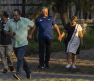 Visto a través de una valla, el presidente de Cuba, Miguel Díaz-Canel, camina con su esposa Lis Cuesta Peraza antes de emitir su voto en un colegio electoral durante el referéndum sobre el nuevo Código de las Familias en La Habana, Cuba.