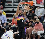 Devin Booker, de los Suns de Phoenix, donquea el balón mientras Anthony Davis, de los Lakers, no puede hacer nada.