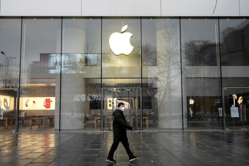 Un hombre camina frente a la tienda de Apple en Beijing, cerrada aún por la cuarentena. (Giulia Marchi/The New York Times)