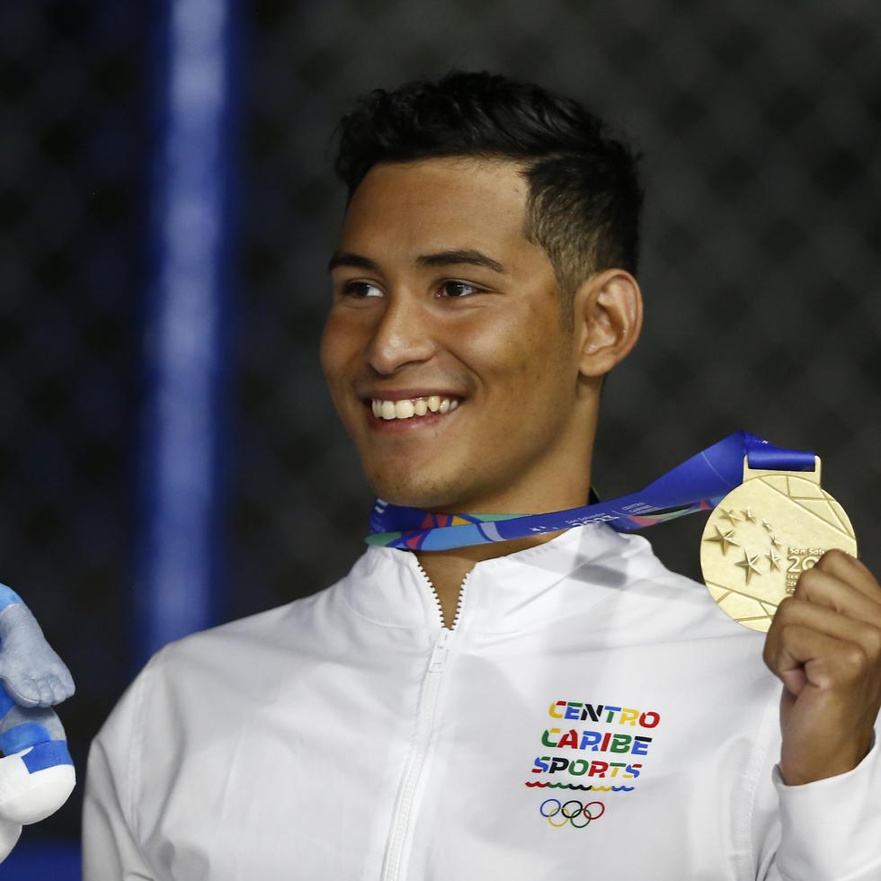 El nadador guatemalteco Erick Gordillo, con el uniforme de Centro Caribe Sports, posa con su medalla de oro.