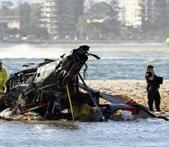Trabajadores de emergencias revisan un helicóptero en el sitio de un accidente cerca de Seaworld, en Gold Coast, Australia, el lunes 2 de enero de 2023.