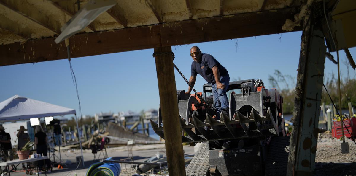 Un contratista endereza un poste en Getaway Marina, que se encuentra en proceso de reconstrucción a causa del huracán Ian, en el Boulevard San Carlos de Fort Myers Beach, Florida.