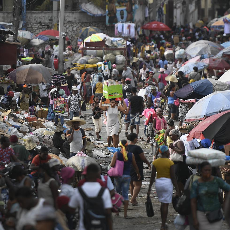 A woman carries a basin with her belongings at the Petion-Ville market in Port-au-Prince, Haiti, Sunday, July 11, 2021, four days after the assassination of Haitian President Jovenel Moise.