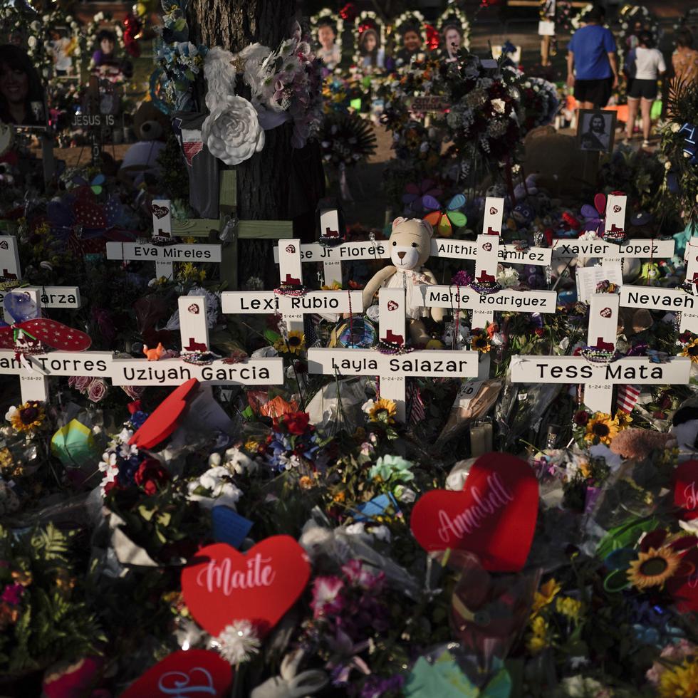 Flores se apilan alrededor de las cruces con los nombres de las víctimas asesinadas en el tiroteo en una escuela de Uvalde, Texas.